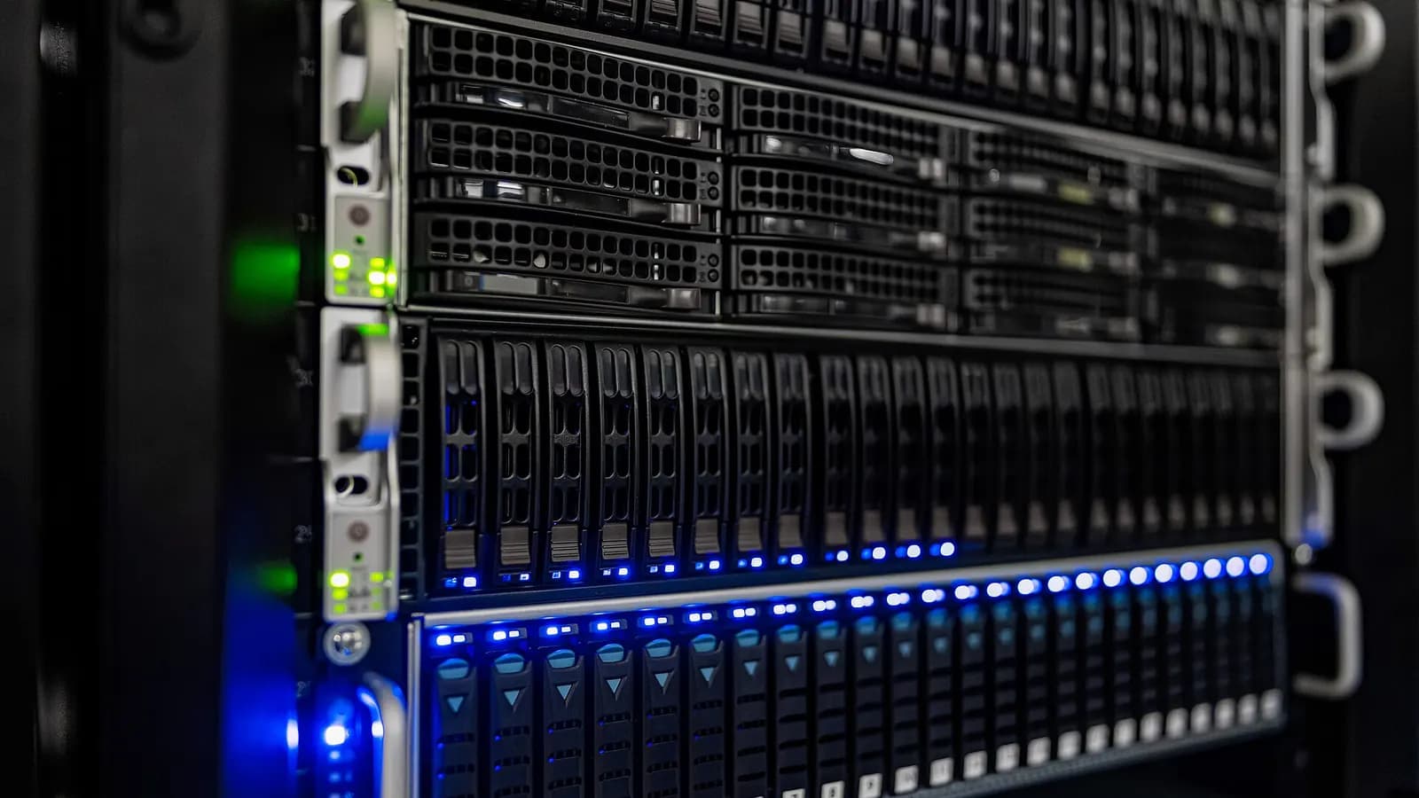 Dark, moody photograph of server racks in a data hall with cool blue light
