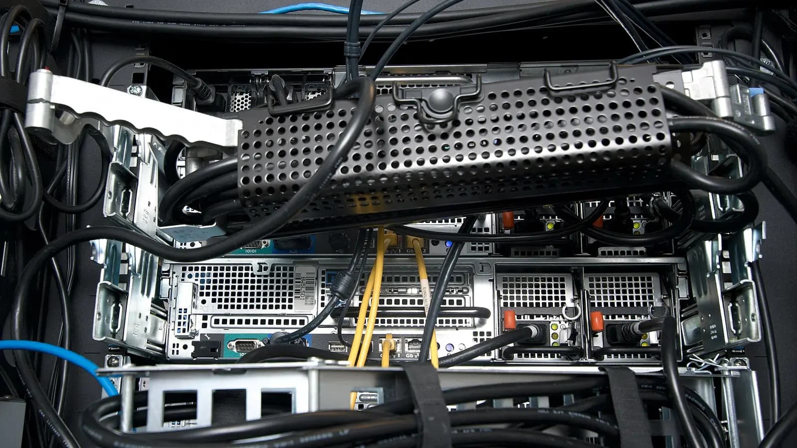 A dense rack of servers with glowing fibre bundles linking it to a distant second rack