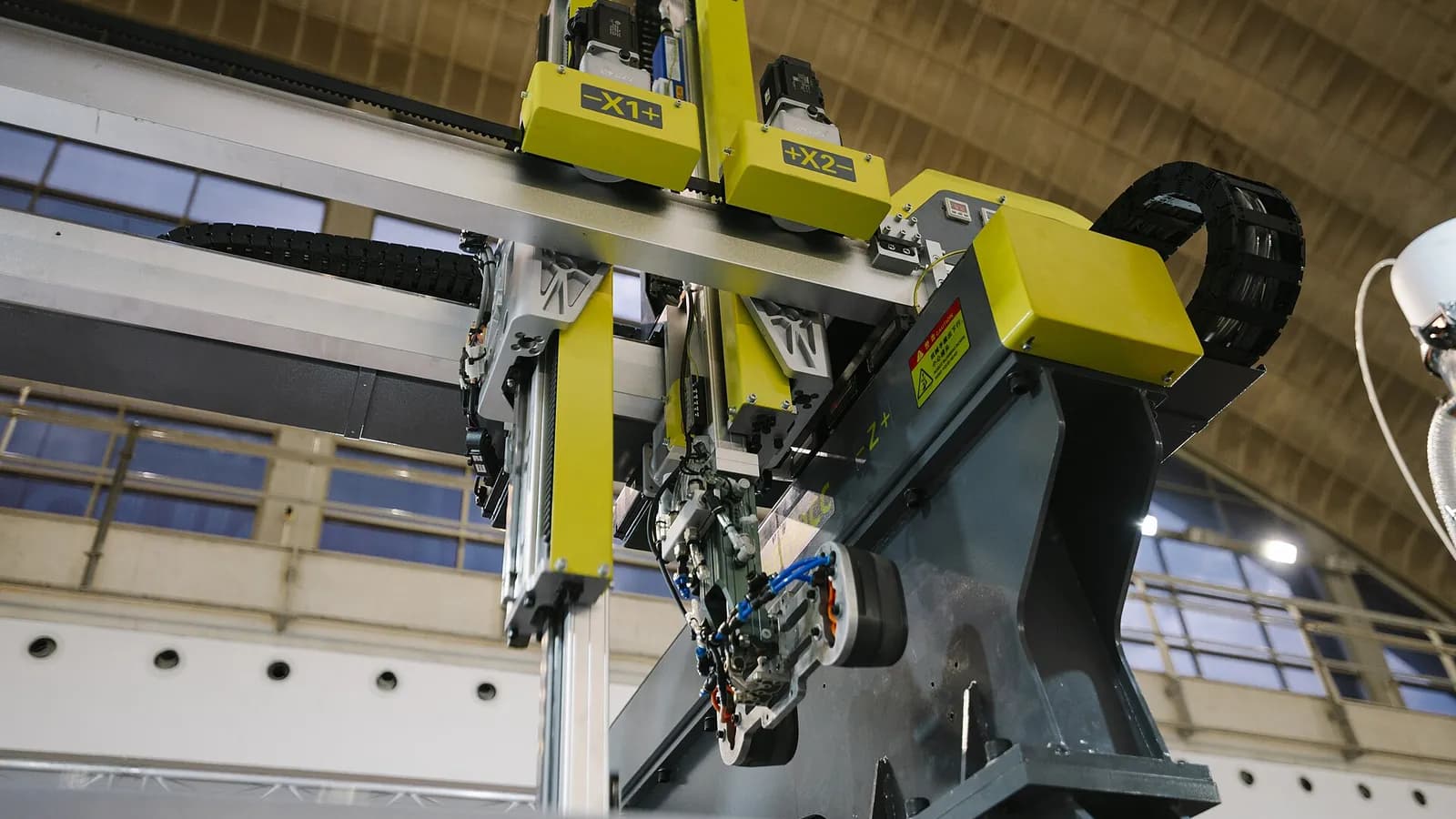 A factory floor with robotic arms and a glowing network of supply routes overlaid